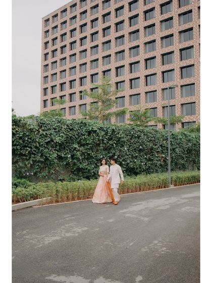 Abhishek and Raashi walk hand-in-hand during their Haldi event. The modern architecture of the Hilton Bangalore provides a unique backdrop for their traditional celebration.