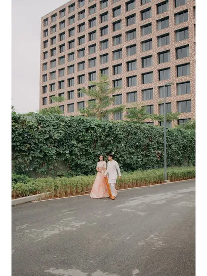 Abhishek and Raashi walk hand-in-hand during their Haldi event. The modern architecture of the Hilton Bangalore provides a unique backdrop for their traditional celebration.