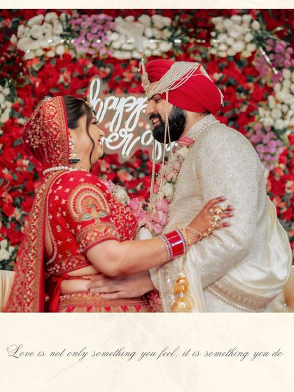 A candid moment of laughter and love between Ishita and Dipender, captured against a backdrop of red and white flowers.
