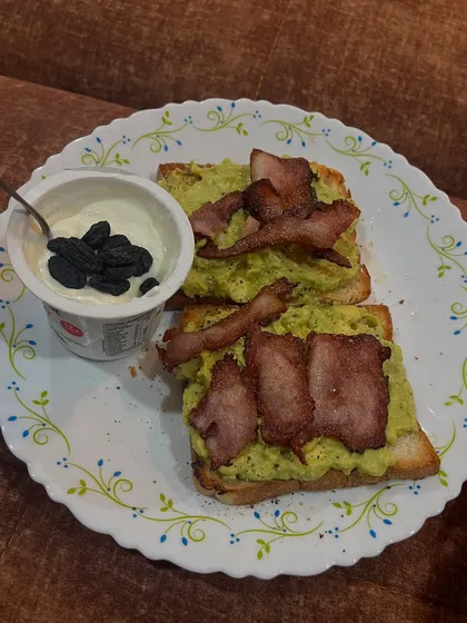 Avocado toast with bacon and a side of yogurt with raisins. This meal is packed with healthy fats and protein to keep me full and energized.