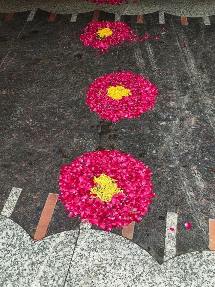 A beautiful floral rangoli made with rose petals on the floor, part of a traditional welcome home decoration for a newborn.