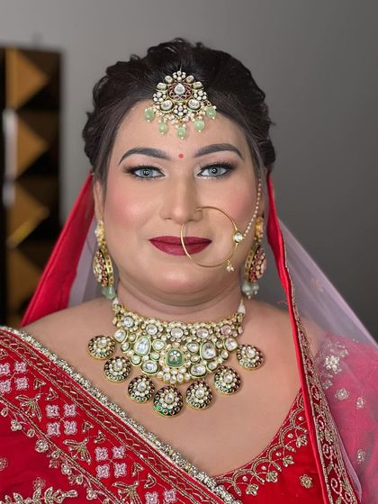 A portrait of the same bride, looking confidently at the camera. Her bold red lip and defined eyes are the stars of this look.