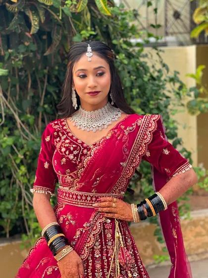 A full-length shot of the bride in her red reception lehenga, looking poised and elegant.
