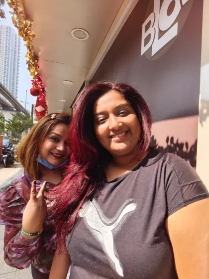 A happy client selfie with her new vibrant red hair. We love capturing these moments of pure joy right after a fresh color transformation.