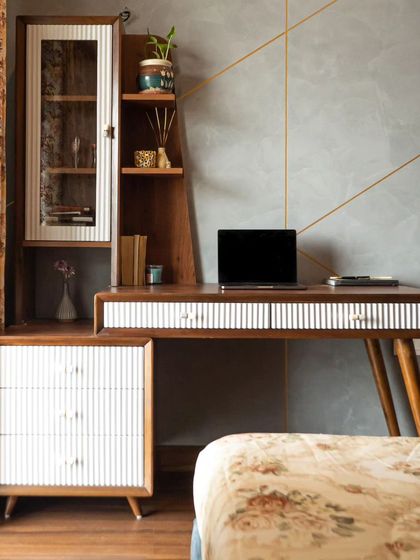 A work desk doesn't have to be boring. This gorgeous mid-century modern study table, with its fluted drawer details and angled legs, adds style to the bedroom while providing a functional workspace.