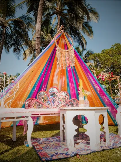 This colorful teepee seating is a great example of creating cozy and photogenic corners at a Mehendi. The dreamcatcher and vibrant drapes add to the bohemian and festive feel.