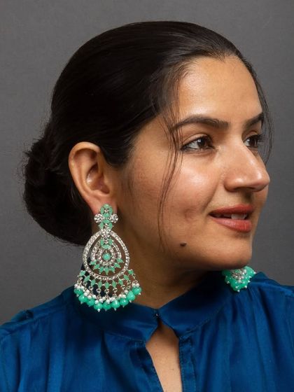Aqua green hues for a refreshing look. These silver-toned chandelier earrings are set with American diamonds and finished with beautiful aqua green beads.