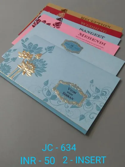 This blue invitation features a gold foil floral design and a central nameplate. The set includes inserts in festive colors for your Mehendi, Sangeet, and Wedding.