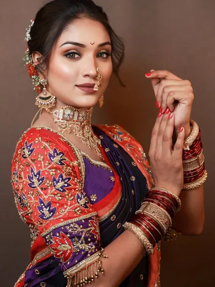 A beautiful Maharashtrian bride in a Paithani saree. The makeup is designed to complement the rich colors of the outfit, with sharp eyes and a traditional bindi.