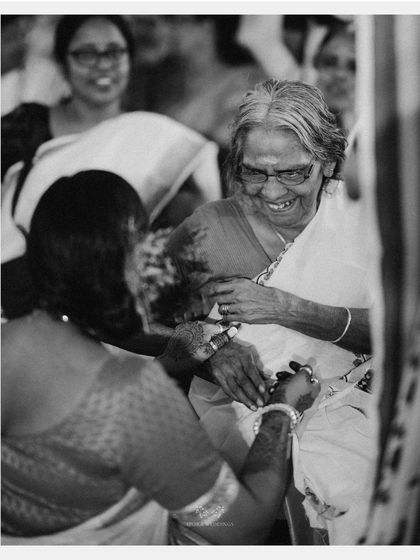 A heartwarming black and white photo of an elder woman's joyful smile, capturing the happiness of family.