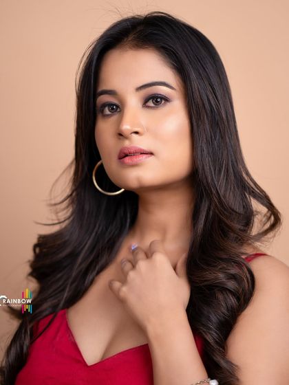 A classic beauty headshot. The soft lighting, simple red top, and neutral background create a timeless and elegant portrait.