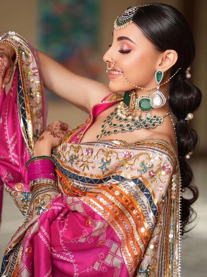 A vibrant and joyful look, perfect for a Mehendi or a Punjabi bride. The colourful phulkari-inspired outfit is paired with fresh, glowing makeup and a playful smile.