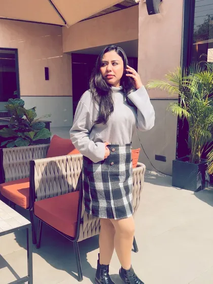 Posing at the outdoor seating area of Camo Noida, showcasing the cafe's modern and chic aesthetic.