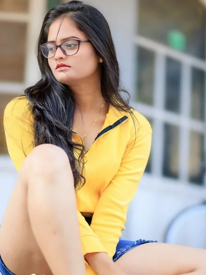 A relaxed and thoughtful seated pose. The natural light is soft and flattering, creating a beautiful, calm mood.