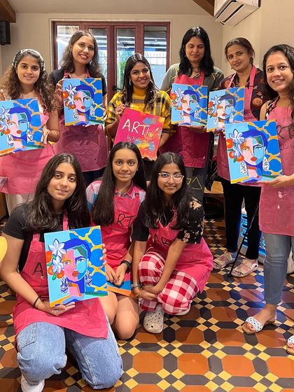 A group of ladies and teens with their abstract portrait paintings. It's a fun and creative activity for a mixed age group.