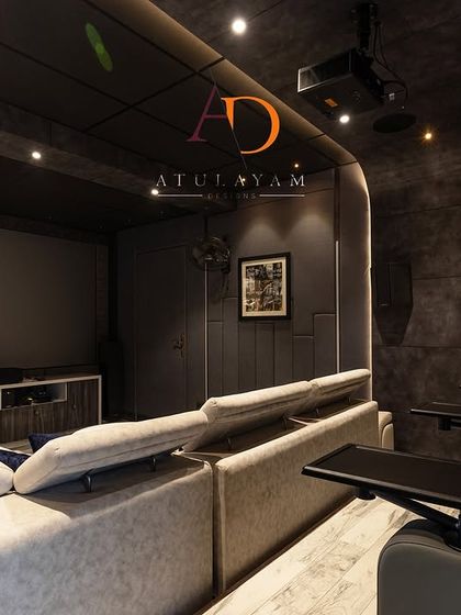 The room includes multiple tiers of seating with both a large sofa and dedicated recliners with tray tables, ensuring comfort for all guests.