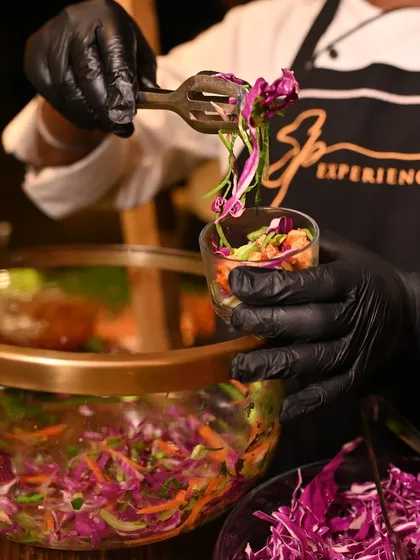 Our chef prepares a fresh, crunchy Asian salad at a live salad station, tossing vibrant ingredients for guests at an anniversary celebration in Kolkata.
