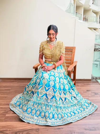 A full-length shot of the bride, looking like a princess in her unique blue and gold Haldi outfit.
