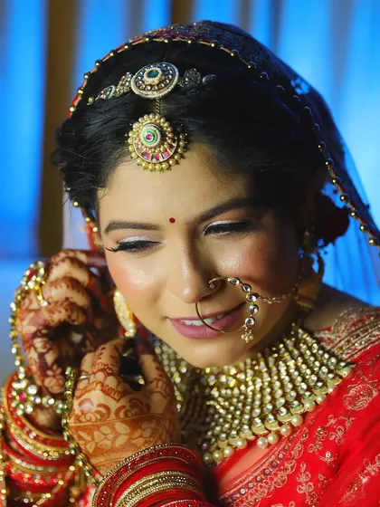 A close-up on the intricate details. The double matha patti and oversized nath are key features of this traditional and glamorous bridal look.