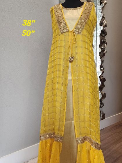 For a touch of festive glamour, this fusion outfit pairs a golden inner dress with a sheer, floor-length yellow jacket. The jacket features delicate embroidery and a ruffled hem, creating a layered look that is both bright and elegant.