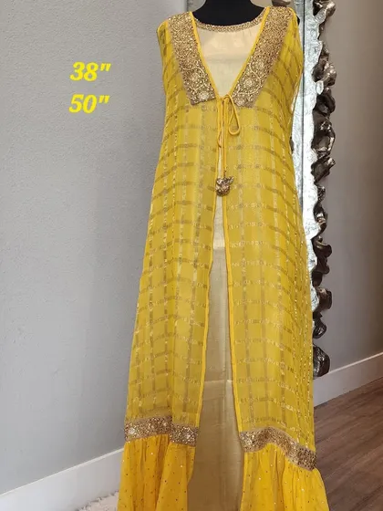 For a touch of festive glamour, this fusion outfit pairs a golden inner dress with a sheer, floor-length yellow jacket. The jacket features delicate embroidery and a ruffled hem, creating a layered look that is both bright and elegant.