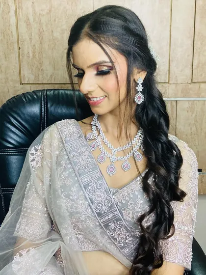 A lovely candid shot of the client admiring her makeup. It captures a genuine moment of satisfaction with her transformation.