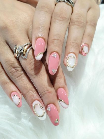 A creative and modern design with a mix of pink and white nails, adorned with gold 3D frames and sparkling rhinestone accents.