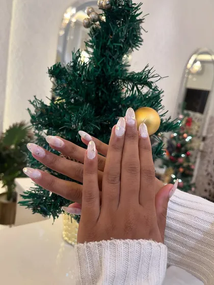 A gorgeous set of winter-themed nails. We used a white marble effect with gold foil flakes to create a look that's reminiscent of a snowy day.