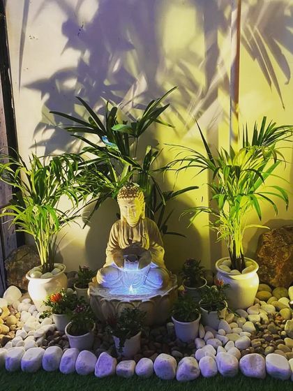 The Buddha water fountain at night, with internal lighting that makes the water glow, creating a magical effect.
