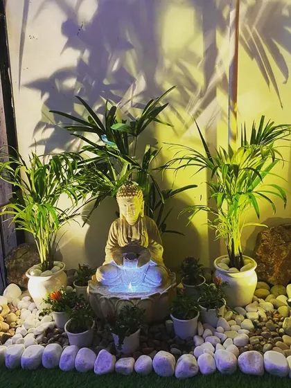 The Buddha water fountain at night, with internal lighting that makes the water glow, creating a magical effect.