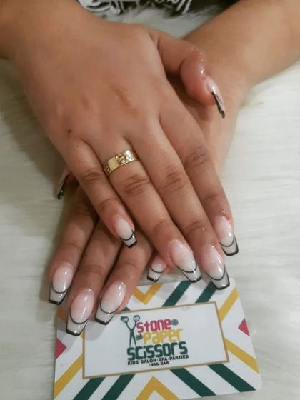 A graphic and modern outline French manicure. I used a thin black line to trace the shape of the nail and the tip, creating a cool, cartoon-like effect on these long extensions.