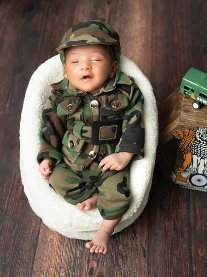 Another adorable shot of the smiling baby in the army-themed setup.