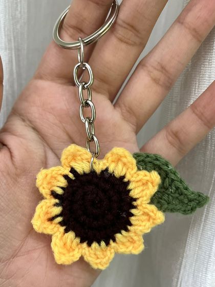 A close-up of my sunflower keychain held in my hand. It's a little piece of sunshine you can carry with you everywhere.