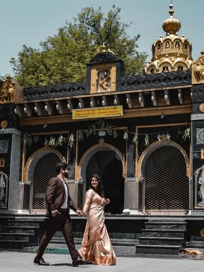 A wide-angle pre-wedding shot of a couple in front of a beautiful temple, showcasing our ability to capture both the couple and the magnificent architecture.