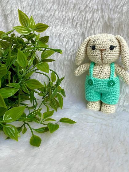 This handsome boy bunny wears a cute pair of sea-green dungarees. His long eyelashes give him such a sweet and gentle expression.