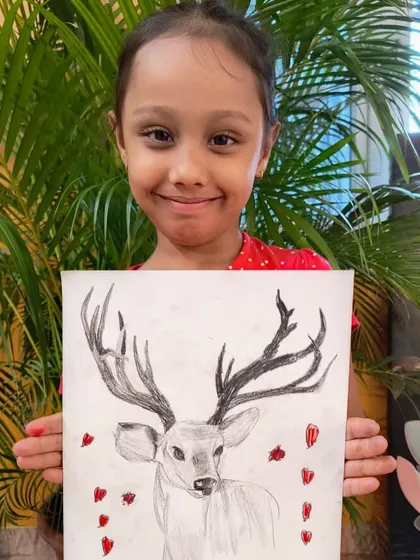 A proud student with her finished deer sketch, showcasing her excellent control of line and shading.