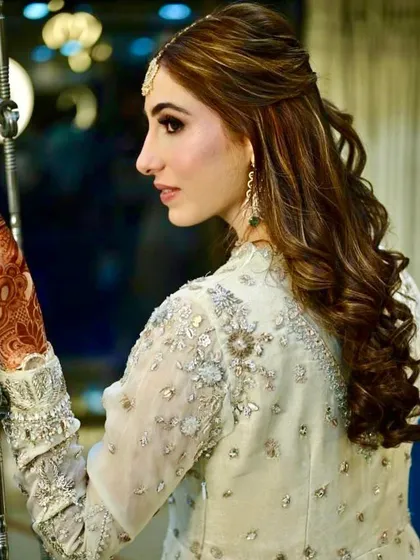 A side profile of the Nikaah hairstyle, showing the soft curls framing the bride's face.