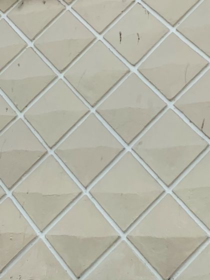 A close-up of the geometric, three-dimensional facade tiles that give the bungalow its unique Art Deco character.