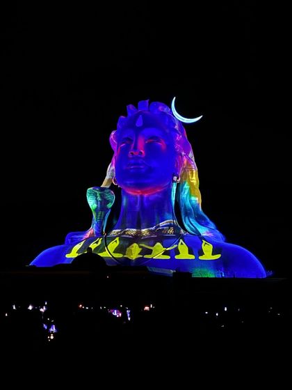 The Adiyogi statue illuminated with vibrant colors during the nightly laser show. This is a highlight of my one-day trip.