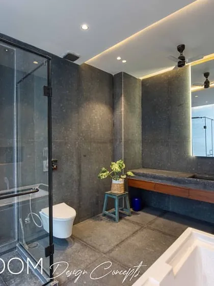 A full view of the master bathroom, showcasing the balance of dark stone, a modern vanity, and a large back-lit mirror.