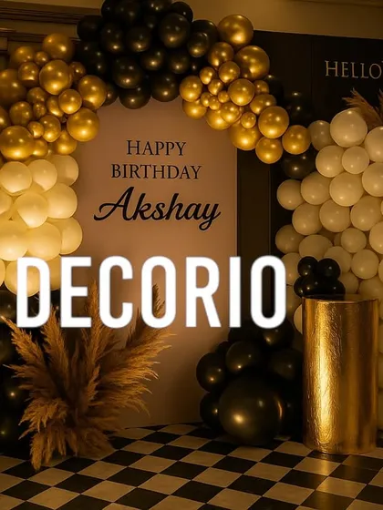 A wide view of a sophisticated 30th birthday party setup. The black, gold, and white balloon arch frames a personalized backdrop, creating a grand entrance and photo area.