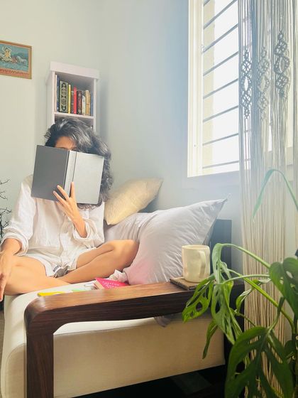 A candid photo of me in my reading nook. I am a child of chaos, but I love to read the rules, especially when I'm challenged to twist and break them.