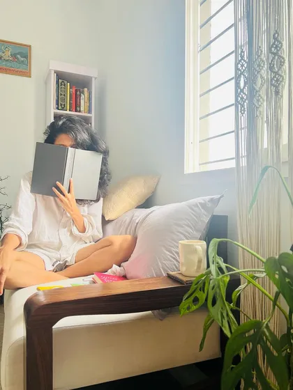A candid photo of me in my reading nook. I am a child of chaos, but I love to read the rules, especially when I'm challenged to twist and break them.