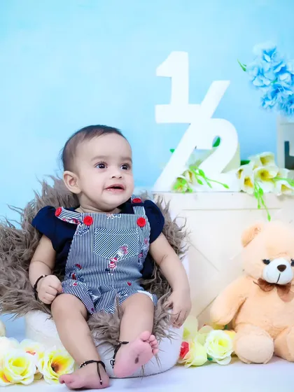 A six-month-old baby boy sitting up confidently during his half-birthday shoot.