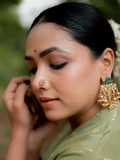 My accessory photography focuses on the fine details that make a piece unique. This macro shot of a traditional nose ring, or 'mooguthi', highlights the craftsmanship and delicate design, making it the hero of the image for a jewelry brand's catalog.