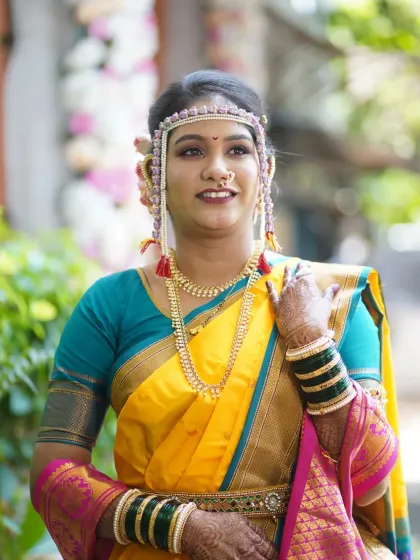 A confident portrait of the bride. Her makeup is flawless, and her hair is neatly tied in a traditional bun, ready for the long day ahead.