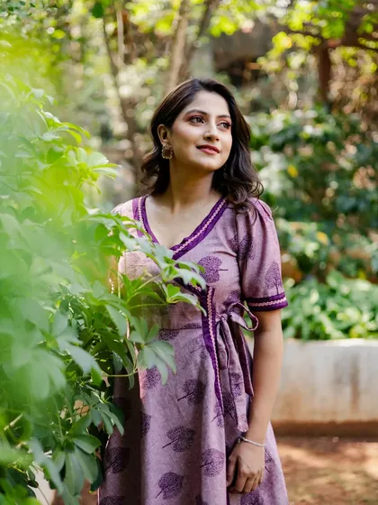 A thoughtful portrait taken amidst greenery. The actress peeks out from behind leaves, adding a touch of creativity and connection with nature to her portfolio.