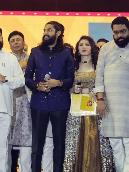 Standing alongside the Chief Minister and other dignitaries on the grand stage.