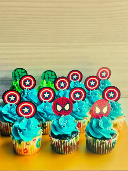 An assortment of my Avengers-themed cupcakes, featuring Captain America's shield, Hulk's fist, and Spiderman's mask. The bright blue and green buttercream makes these mini treats visually pop on any party table.
