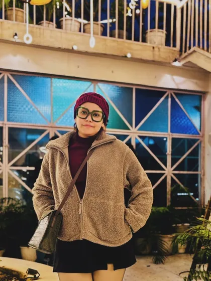 A cozy winter look with a fleece jacket, beanie, and glasses, perfect for a chilly evening out.